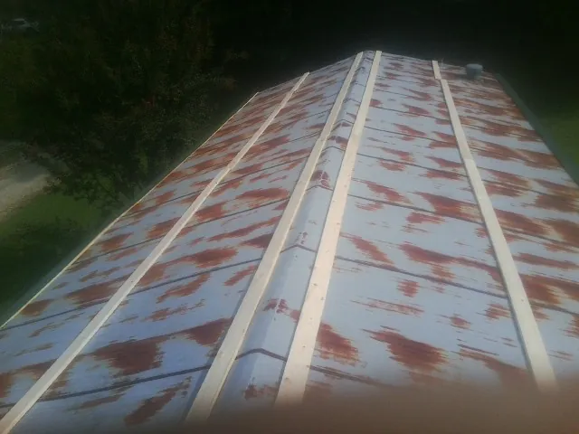 Rusted metal roof panels with new wood purlins before replacement — Storm Damage Roof Repair in Bedford by Roofing Brothers